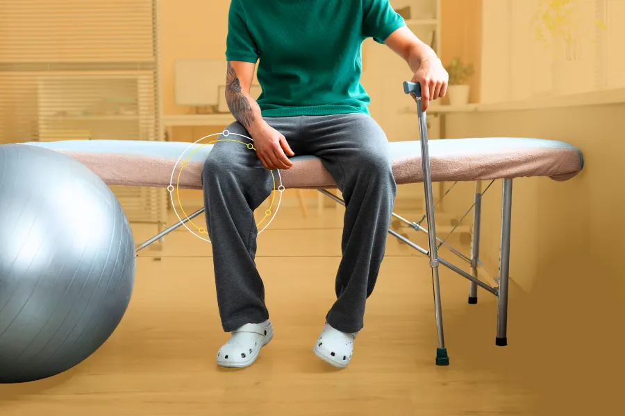 Man holding walker sitting on a bench in a physical therapist room